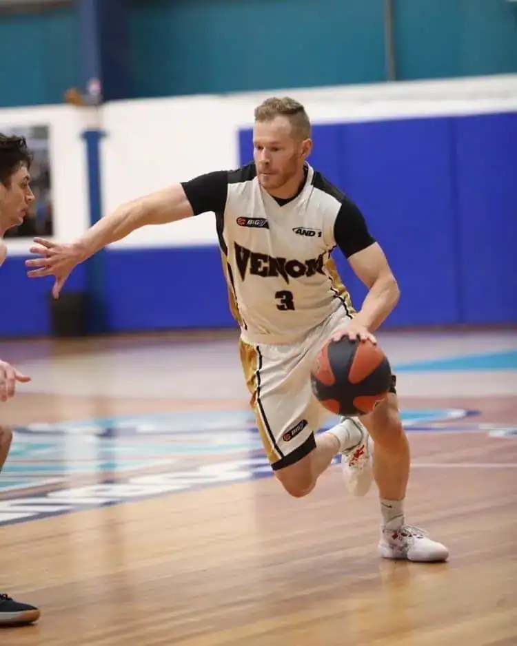 Athletic basketball player dribbling during game at No Limits Basketball facility in Australia.
