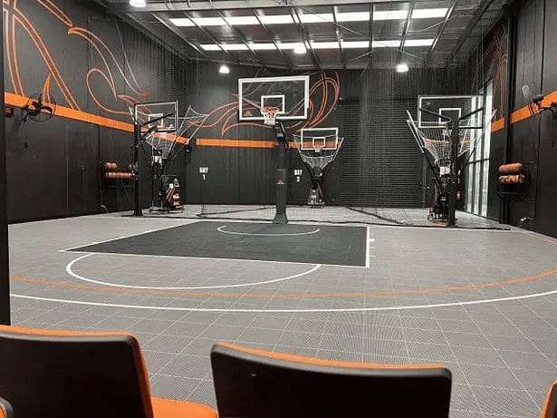 Modern indoor basketball training facility with multiple hoops and professional court for basketball practice and skills development.