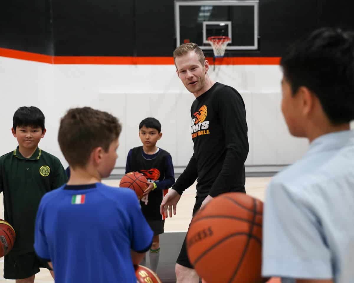 Basketball coach coaching kids during training at No Limits Basketball, indoor sports facility in Australia.