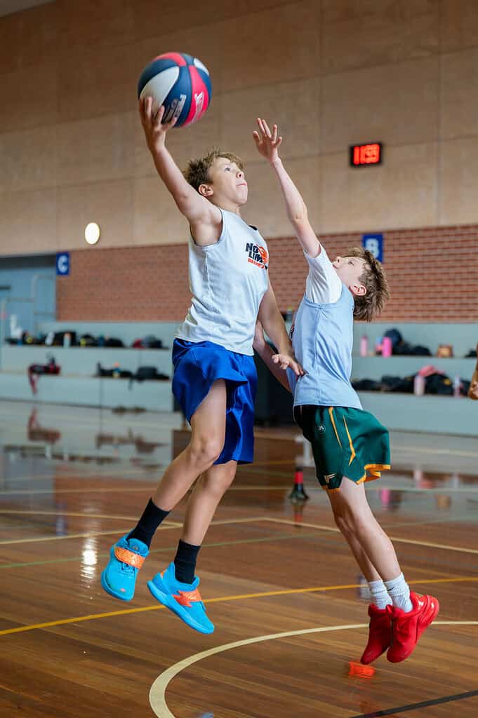 Young boys playing basketball in indoor court for No Limits Basketball.