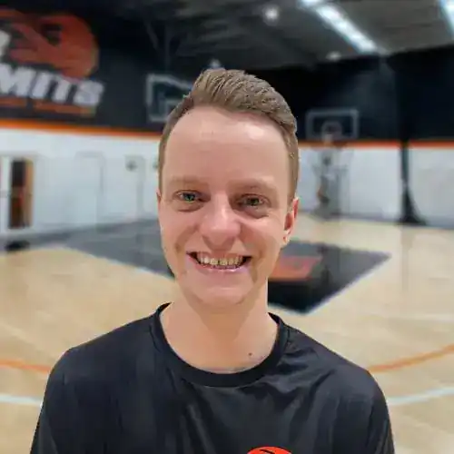 Smiling basketball player at No Limits Basketball indoor court.