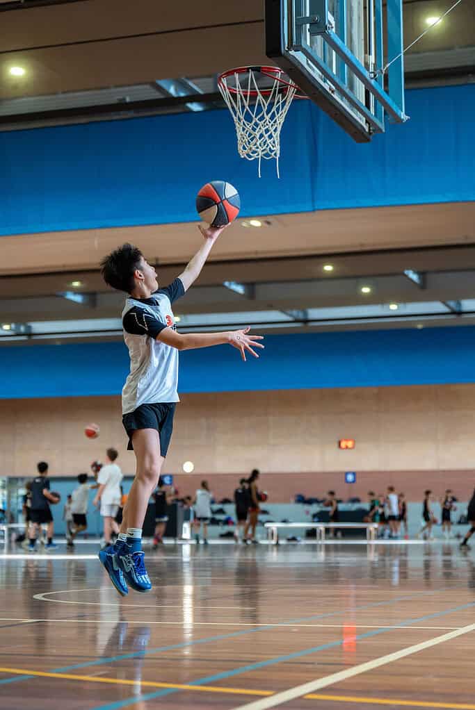 Young boy jumping to score a basket at No Limits Basketball.